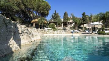 Una piscina al aire libre de temporada, sombrillas