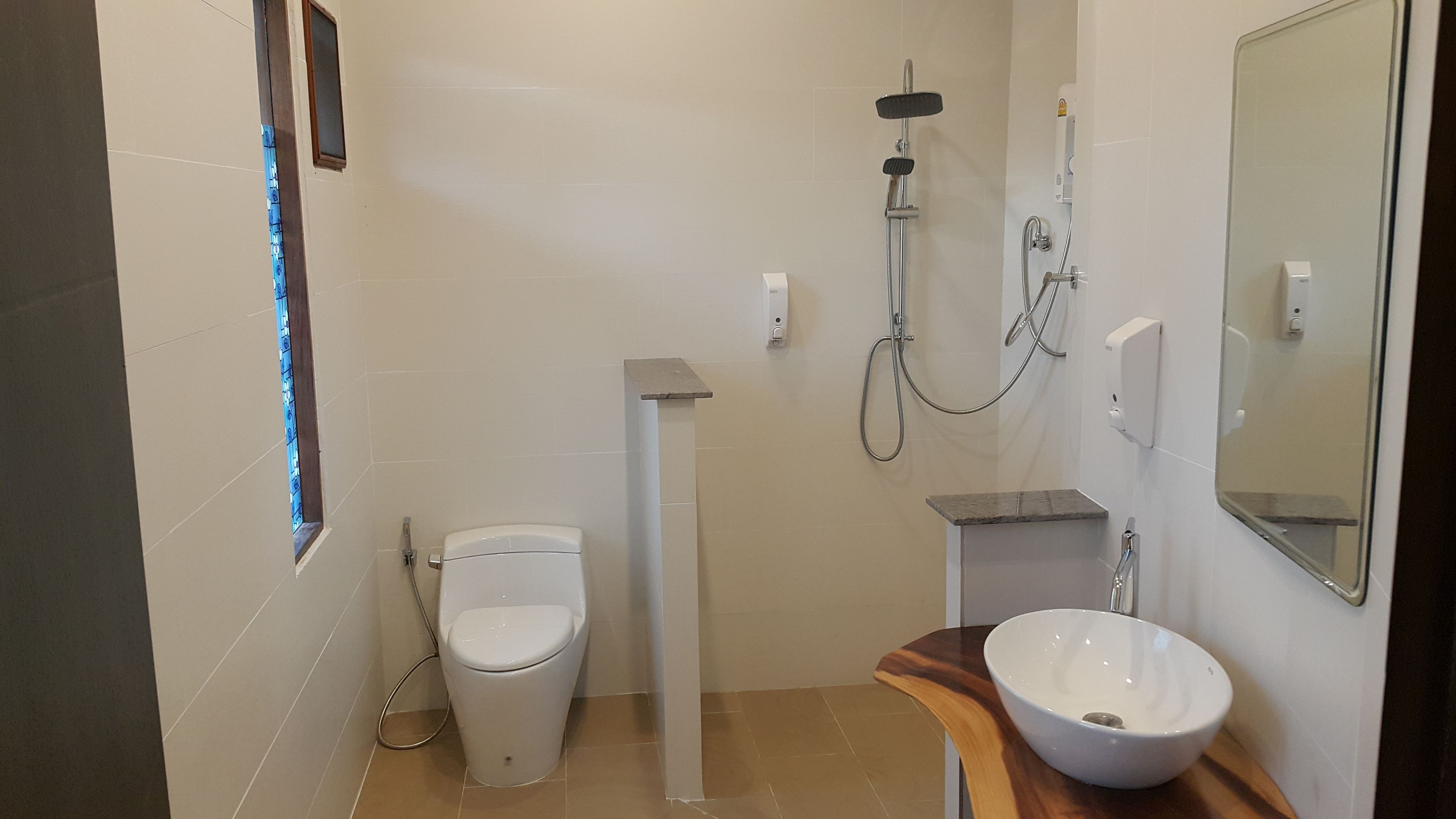 Un baño moderno con inodoro, ducha y lavabo.