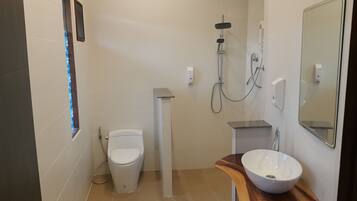 Un baño moderno con inodoro, ducha y lavabo.