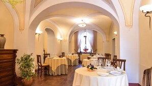 A dining area with round tables, chairs, and a chandelier. - Villa Floridiana (Anagni)