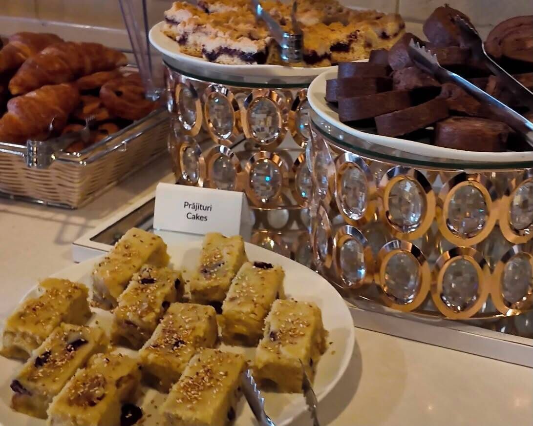 A buffet with various desserts including cakes, pastries, and a plate of what appears to be a type of fudge.