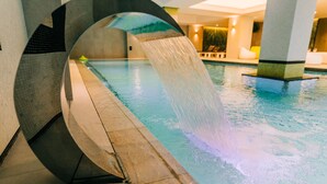 A modern indoor pool with a unique circular water feature. - Mandachi Hotel & SPA (Suceava)