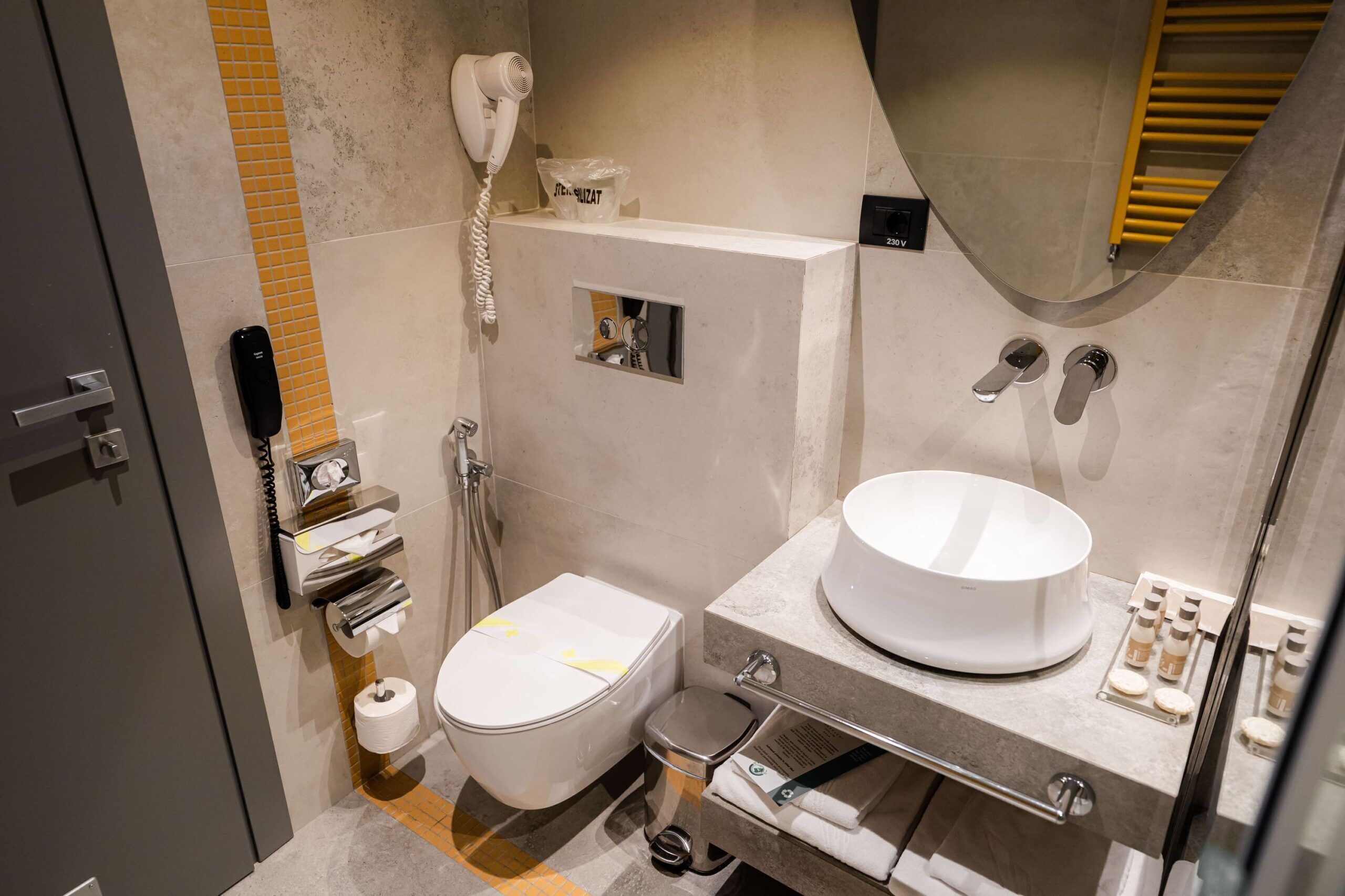 A modern bathroom with a toilet, bidet, and a large sink.
