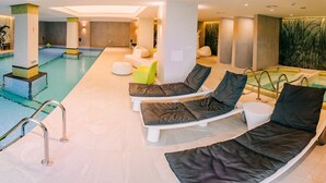 A modern indoor pool area with lounge chairs and a small hot tub. - Mandachi Hotel & SPA (Suceava)