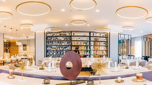 A modern hotel lobby with a wine cellar, round ceiling lights, and a central decorative piece. - Mandachi Hotel & SPA (Suceava)