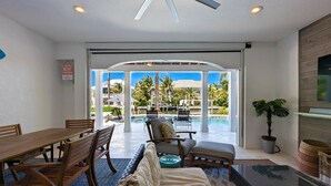 A room with a dining area, a pool view, and a large window.