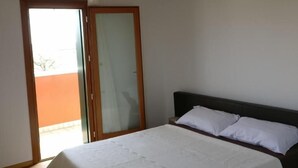 A bedroom with a bed, a wooden ceiling, a sliding glass door, and a view of the outside. - Oleaclub Locazione Turistica (Maser)