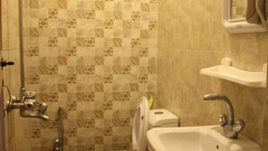 A bathroom with a toilet, sink, and shower. - Baltit Heritage Inn (Karimabad)
