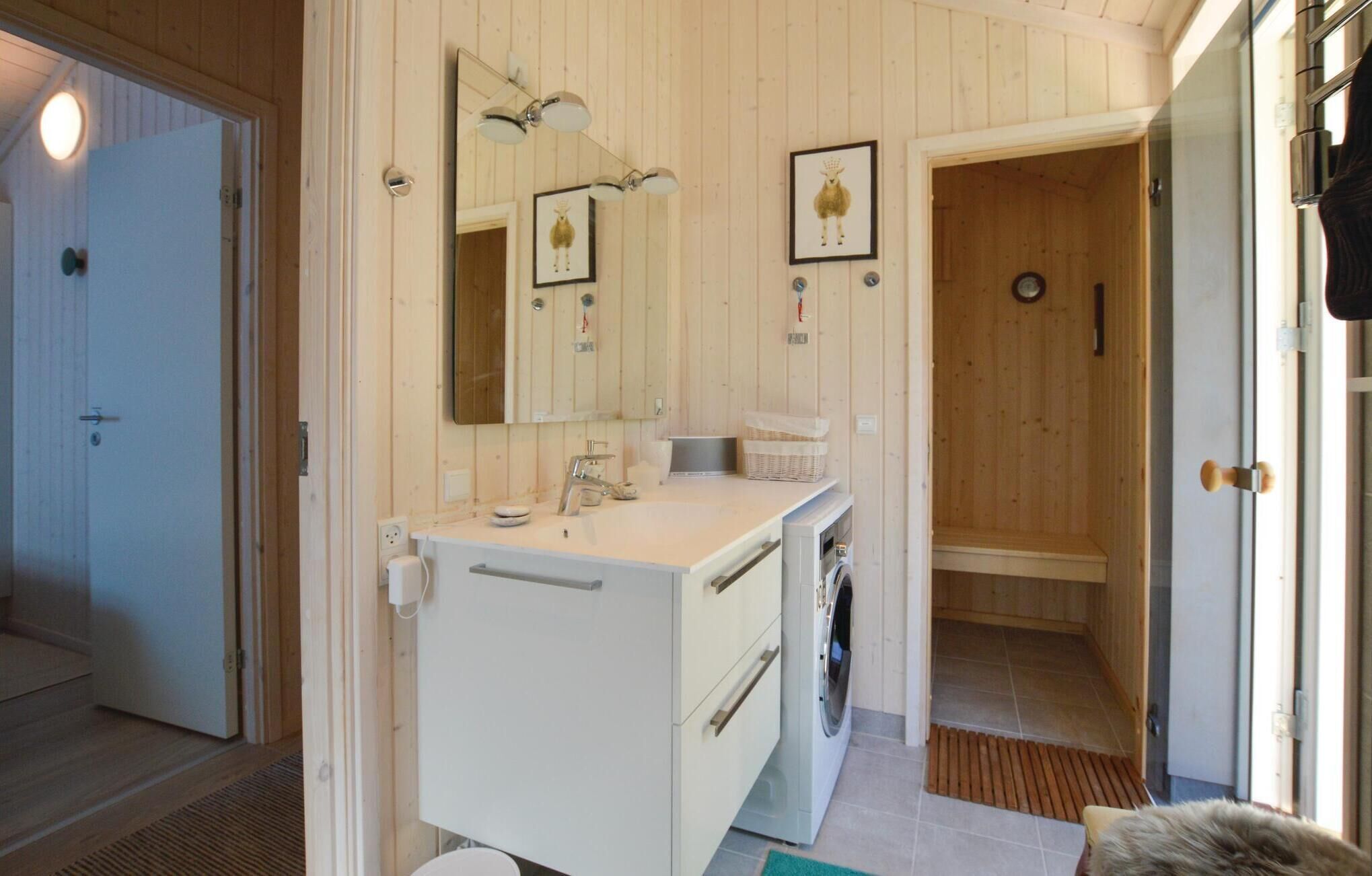 Une salle de bain avec un intérieur en bois, un lavabo, un miroir, un porte-serviettes et un espace douche.
