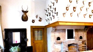 Una habitación con chimenea, una puerta de madera y una pared de piedra con una chimenea.