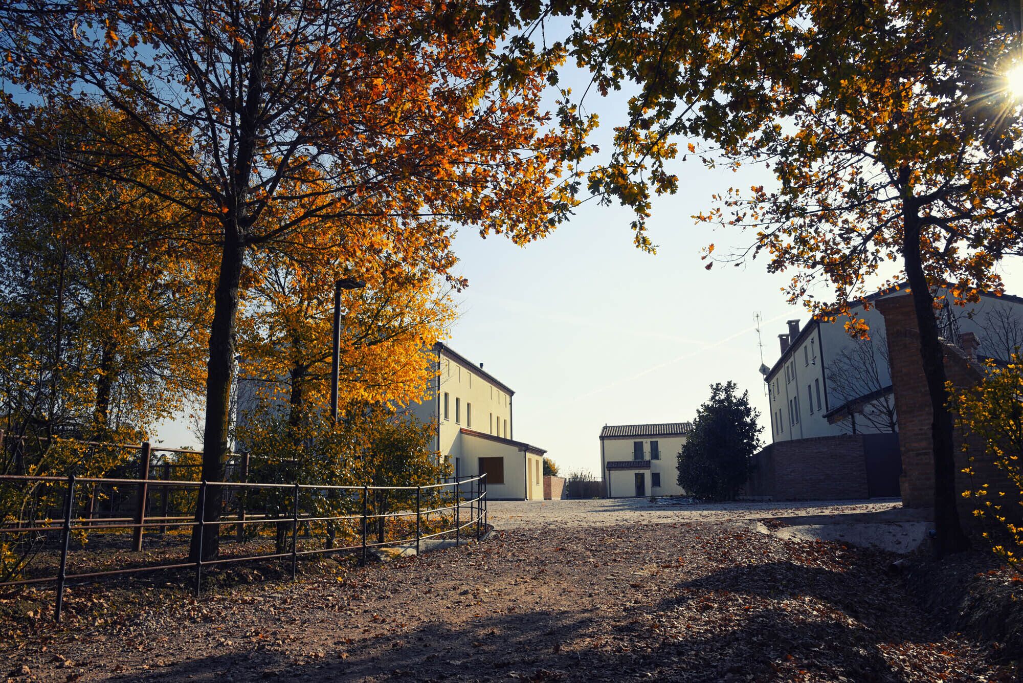 Un chemin menant à un bâtiment entouré d’une zone délimitée par une clôture.