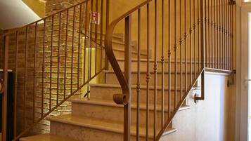 A staircase with a stone pillar, metal railing, and a door at the top.