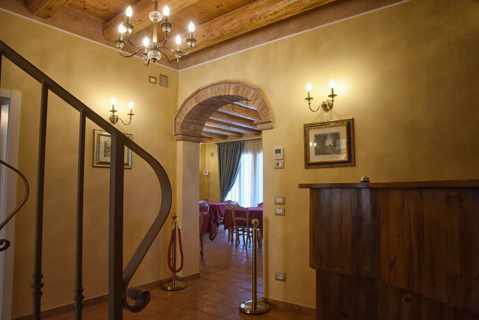 Eine prächtige Treppe mit einem Chandelier, ein Holzbüro und ein Essbereich mit Tischen.