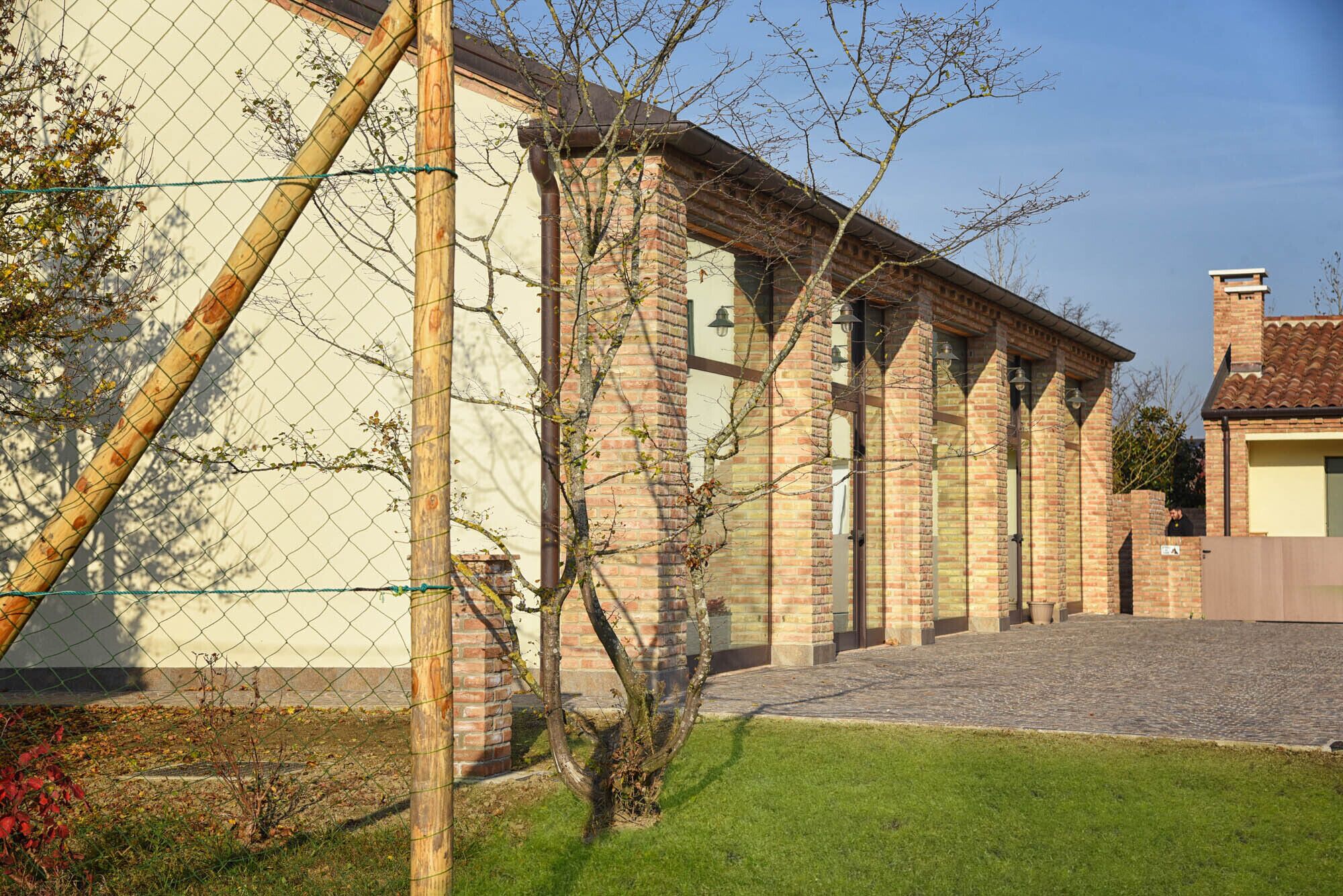 A brick building with a covered walkway and a fenced area.