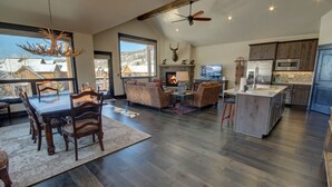 A spacious living area with a fireplace, dining table, and comfortable seating. - River Run Townhomes 63 (Keystone)
