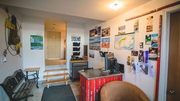 A compact living space with a desk, chair, and a small seating area.