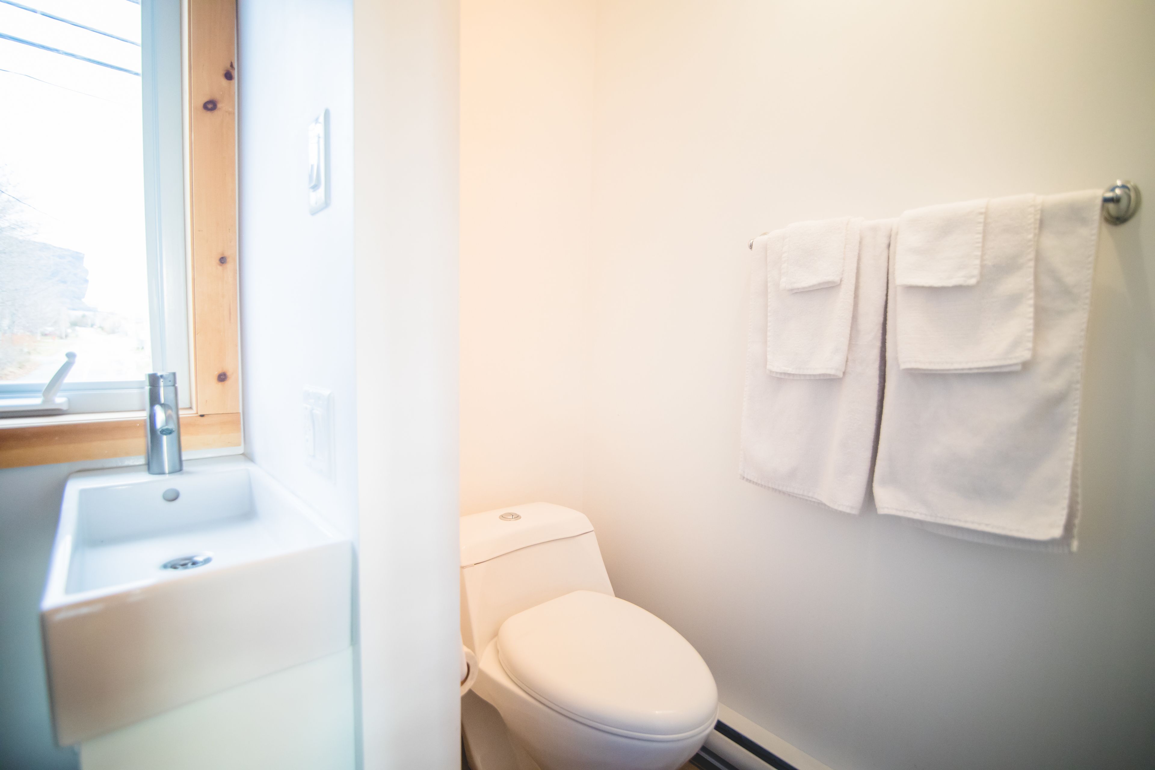 A bathroom with a white sink, toilet, and towel rack.