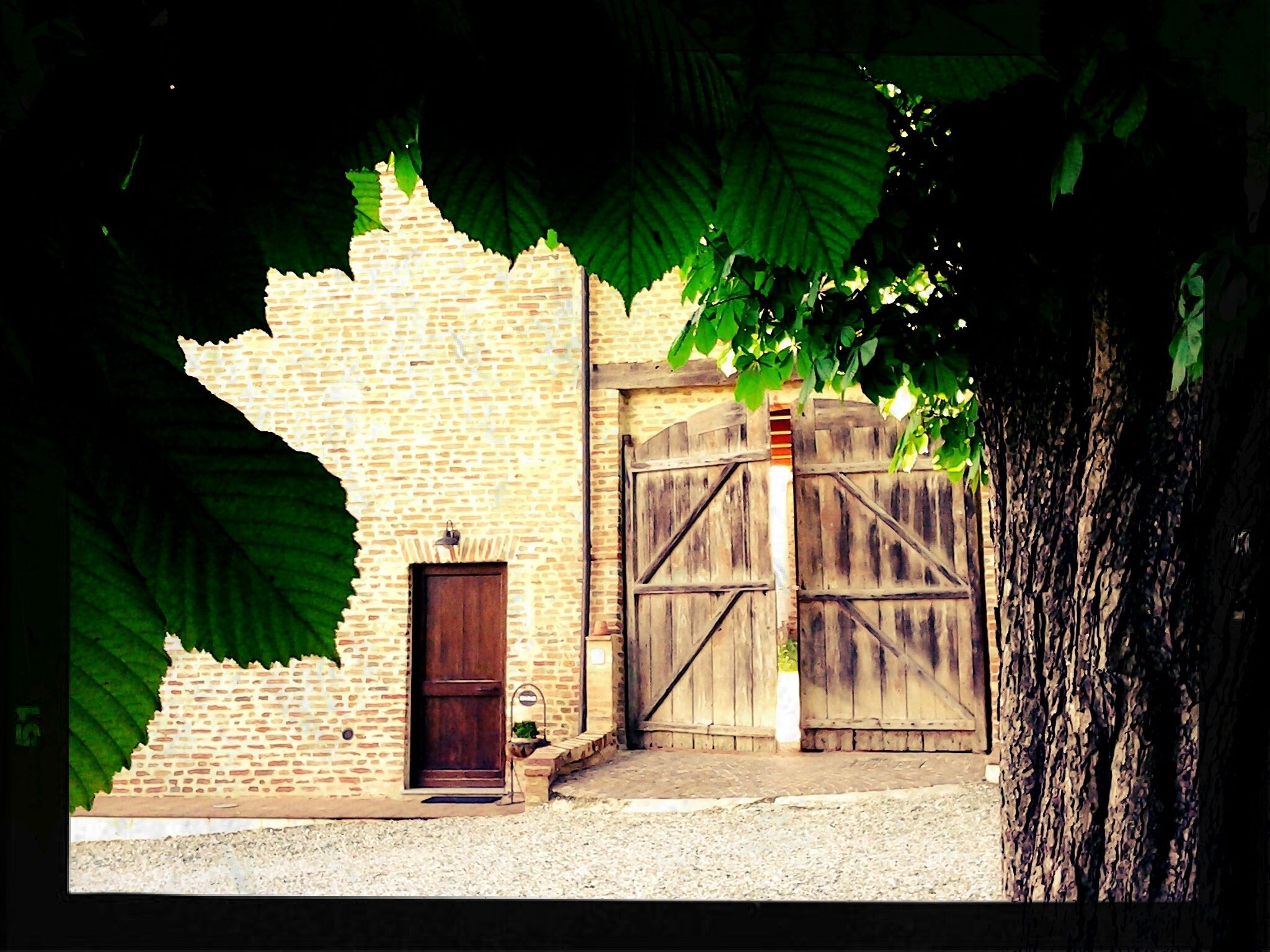 A rustic building with a brick facade, a wooden door, and a large wooden gate.