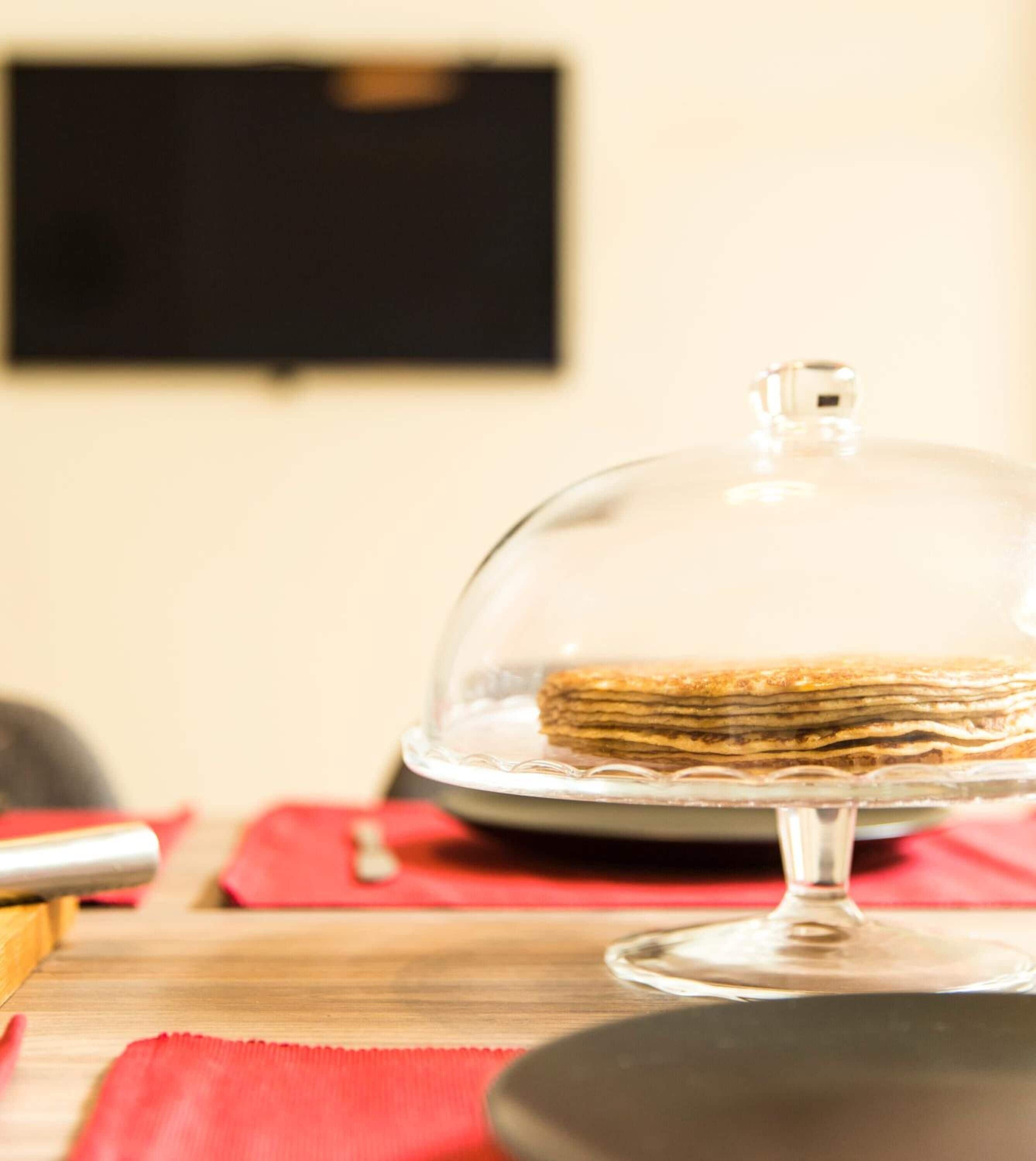 A dessert on a glass stand with a dome cover.