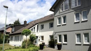 A residential building with a paved driveway, multiple windows, and a well-maintained garden area. - Apartmenthaus Somborn (Bochum)