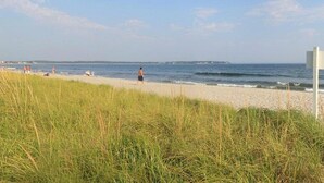 A beach with a grassy foreground, a sandy beach, and the ocean in the background. - Holiday House Inn (Scarborough)