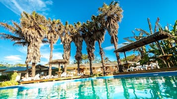 Een buitenzwembad, ligstoelen bij het zwembad