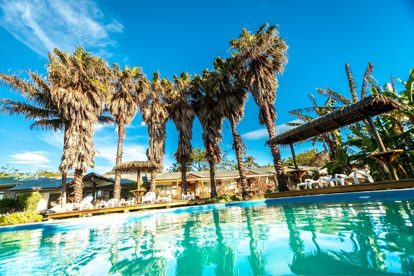 Una piscina al aire libre, sillones reclinables de piscina