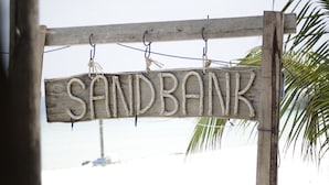 A wooden sign with the word "SANDBANK" hanging from a wooden structure. - Sandbank Restaurant & Camping Koh Rong (Koh Rong)