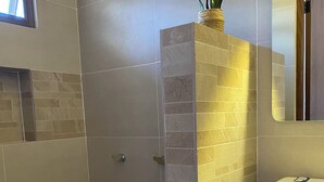 A bathroom with a shower, a sink, and a mirror. - Hotel San Julio (Celestún)