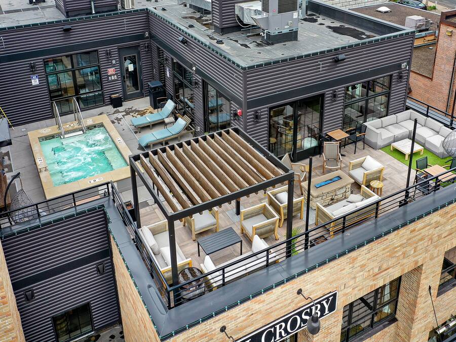 Una terraza con piscina, asientos al aire libre y una zona de bar.