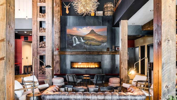 A cozy lounge area with a fireplace, comfortable seating, and a large wall-mounted TV.