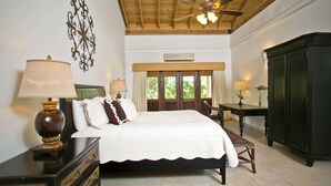 A bedroom with a bed, bedside tables, a desk, a wardrobe, and a ceiling fan.