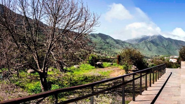 Un sentier menant à un bâtiment avec une montagne en arrière-plan.