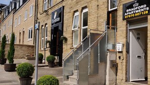 A row of townhouses with a 'Bud Room' sign, a staircase, and a 'Snooze' sign.