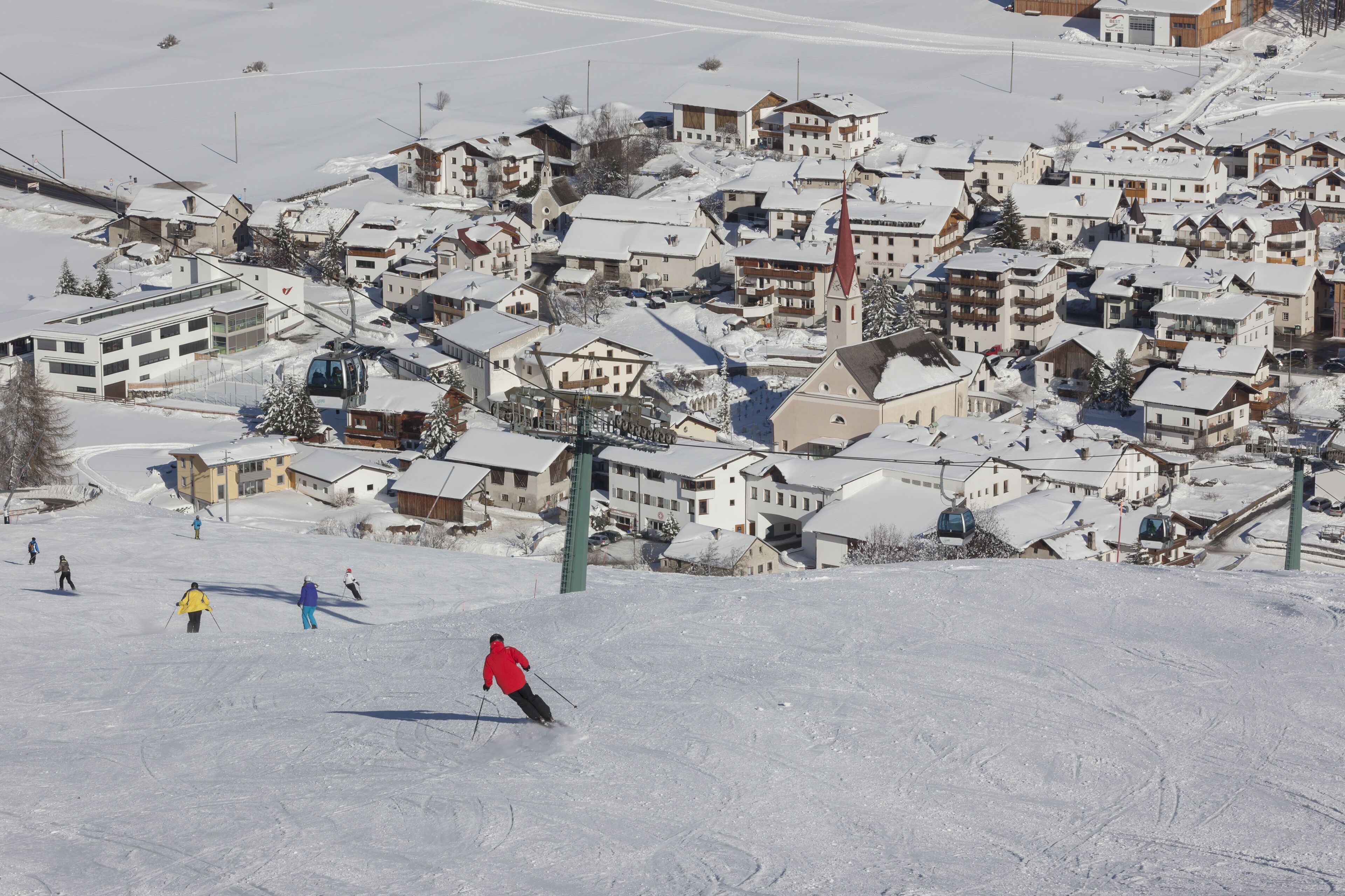 Un centro de esquí con edificios cubiertos de nieve y un telesilla.