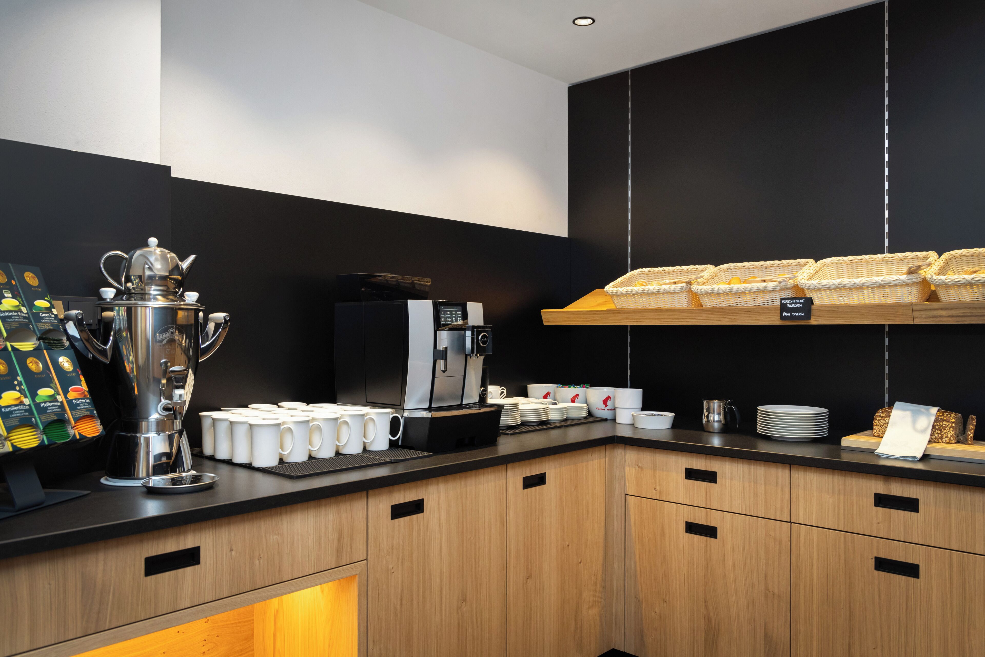 Une cuisine moderne équipée d’un coin café, comprenant une machine à café, des tasses et une théière.