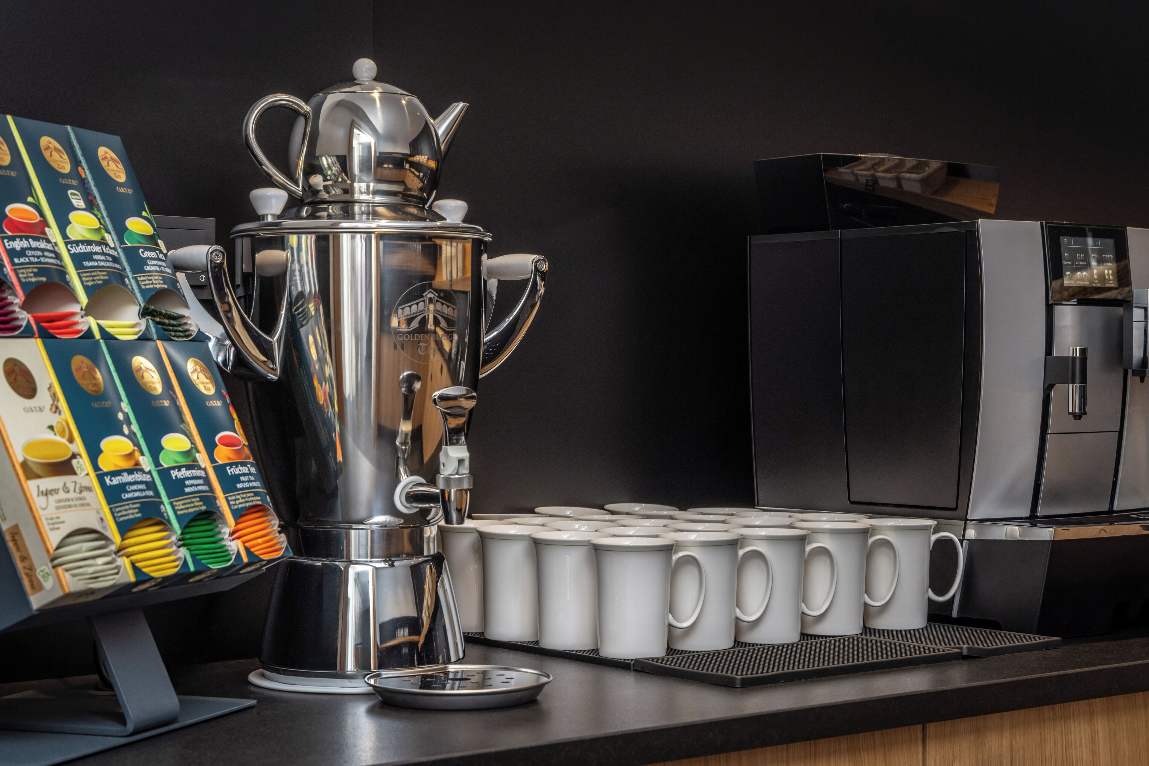 A coffee station with a coffee pot, a menu board, and several coffee cups.