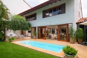 A two-story house with a swimming pool, outdoor seating area, and potted plants. - Claro de Luna by Casa de Campo Resort & Villas (La Romana)