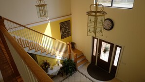 A staircase with wooden railings and a white wall with a framed picture. - Seams Like Home B&B (Connellsville)
