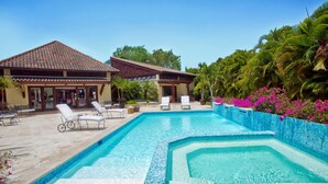 A swimming pool with lounge chairs and a building in the background.