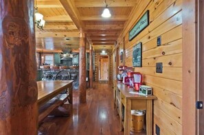 A wooden interior with a long hallway leading to a kitchen area. - Luxury Lakefront Estate on 138 Acres -  Pickleball, Reunions & Weddings (Otisfield)