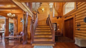 A wooden staircase leading to a second floor in a log cabin-style building.