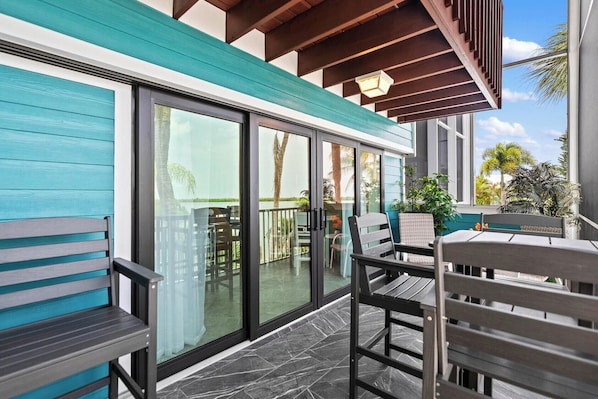 A modern outdoor seating area with a glass door leading to a poolside.