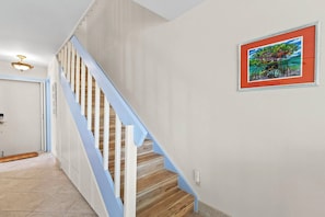 A staircase with white railings and wooden steps leading to a landing.