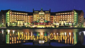 A large, multi-story hotel with a prominent central building and a reflection in the water. - Tranquilla Villa. Bi Level Deck, HOT TUB, fire pit, grill, Movie & Game Rooms! (Tobyhanna)