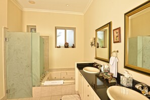 Une salle de bain avec une baignoire, un lavabo et un grand miroir.