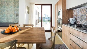 Eine moderne Küche mit Holzausstattung, einem Gasherd und Blick ins Freie.