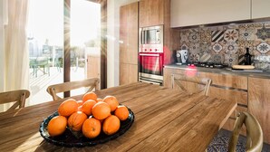 Eine moderne Küche mit Holzschränken, einem Edelstahlbackofen und einer gefliesten Spritzschutzwand.