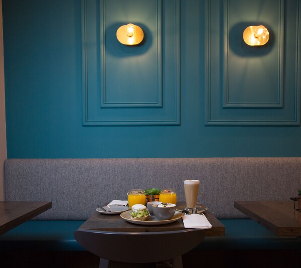 Un comedor con una mesa dispuesta para el desayuno, que incluye un tazón de sopa, un plato de huevos, un vaso de jugo de naranja y una taza de café.