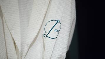 A white robe with a monogram embroidered in blue.